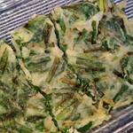 八方美人 - ニラチヂミ 　キッチンバサミでカットしてみました　家庭では真似できないもちもち 具合です　もち米でも入っているのかな？未だに真似できない このモチモチ感