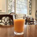 ファンタジースプリングス・レストラン - 店員さんが運んできてくれたにんじん　マンゴーとなんとかのスムージー　壁も床も椅子もテーブルも音楽も全てがかわいいです