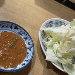 松よし - 串焼き用の味噌ダレ(左)＆お通しキャベツ(右)