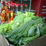 GIA DINH - レジ横、足元の段ボールに山積みになったベトナムの高菜。日本の高菜と違って軸が厚くて広いです。これがあの食感を生むのね(^^)