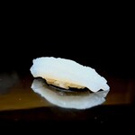 くるますし - イカ。 アオリイカ。 少し白く飛んでますが、縦横に包丁が細かく入ってます。 こうすると旨味、甘みが素早く味蕾に届きますからね。 だけど、僕は、スーッと3,4本、包丁を入れて、パキッとした食感からゆっくり甘みが届くイカのほうが好きなんです。 このあたりから、お腹がきつくなってきて、大将に、タネもシャリも少なめでお願いしました。 フォルムがシャープになってるでしょ？