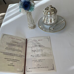 邸宅レストラン　雅俗山荘 - 真っ白なテーブルに青いお花が飾られてます
      隣のオシャレなケースにはバターが入ってます