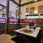 鉄板酒場 お好み焼き 大五郎 - 店内は白い天井、写真入りメニューやポスターが貼られた白壁&下から50cmほどは壁紙の壁、客席は板の間の小上がり、土間部分はタイル貼り床、お好み焼き屋さんというよりも居酒屋さんぽい雰囲気です