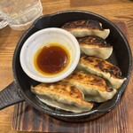 日本栄光酒場 ロッキーカナイ - 焼き餃子！熱々の鉄板で供される餃子は、皮が厚めでしっかり焼き色がつきカリッとした歯応えがいい。反面、餡は肉中心の配合でめちゃくちゃジューシー！この食感のギャップが美味さと満足感を高める！