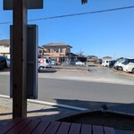 いこい - お店からでたところ　前方の道の向こう側に区画された駐車スペースがたくさんあります