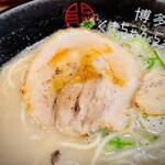 博多 くまちゃんらぁめん - 何かが掛かってるチャーシューは薄めのスライスだけど、肉と脂のバランスが良くて噛み応えとトロッと感を両方を楽しめる。