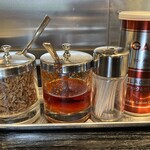 支那ソバ 小むろ - フライドオニオンとワンタン用の辣油が調味料として置かれています。