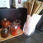 そらのいろ麹町本舗 - 卓上にはﾍﾟｯﾊﾟｰﾐﾙの胡椒、一味がある。髪留め、紙エプロン、荷物かごのサービスもあり