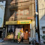 マスカレード - 建物全景。並ぶ際に付近の店舗に迷惑にならないように並ぶ方向をお願いする張り紙。人気店も大変ですね。一番客、最初のオーダーでも、ランチで20分、ツインランチは30分出来上がりまでにかかった。