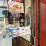 魔界ラーメン 月光 - ドアは「押して下さい」という表示もあるので一見すると自動ドア。しかし張り紙にもある通り普通に手動なので、即座に締めましょう。