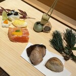 京橋 鮨 好日 - 【前菜】 ・松笠烏賊黄金焼 ・竹萵苣薹 ・梅花蕪なます ・サーモンとトマトの博多寄せ ・竹串刺（子持ち昆布、八幡牛蒡、蓬白玉） ・寒ブリ柚香焼 ・福白子味噌漬焼 ・百合根黒豆茶巾