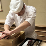 片折 - 鰹の本枯節をお弟子さんが一所懸命に削るのをただただ見つめてお料理の過程を垣間見る。削った鰹節を白湯を注いで雑味のない一番出汁を頂く