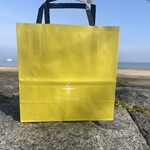 FUSE - お買い上げしたお菓子を入れてもらった袋。後に見えるのは琵琶湖。