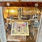 中洲屋台長浜ラーメン初代 健太 - ボタンを押すとローラが稼働して紙幣を吸い込みます