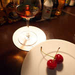 バーポラリス - 皿にチェリー、グラスにはブランデー