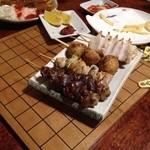 紀八 - 串焼き1本１００円～を何種類かチョイス。　勝負の終わった将棋盤の上に普通に置いていくとかウケる。