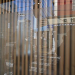 弘明寺丿貫 - 窓。向かいの眼鏡・時計店が映っている