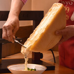 ワインの森 PAR AVION - 料理写真:ラクレットを削り落とすシーン