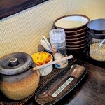 宮古島とんかつ 琉宮 - テーブルの上にはトンカツソースや、自分で摺る胡麻など。