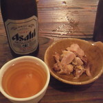 麺場 ハマトラ - 瓶ビール（４７０円）お通しは鶏肉です。独特の酸味が付いているのでついつい箸が伸びちゃいます