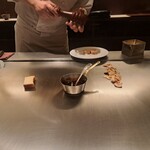 日比谷 モンシェルトントン - 鉄板の上で、ワイン風味のソースを温めながらパンも焼いている様子です。