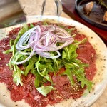 POSILLIPO cucina meridionale - 幻の牛　伊江島牛のスコッタータ・仕上げにガーリックハーブオイルをかけて仕上げる生の牛薄切