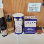 タンタン - 卓上。調味料は酢､ホワイトペッパー､ブラックペッパー､豆板醤(赤唐辛子ペースト？)､摺り下ろしニンニク。