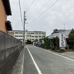 長生うどん - 幹線道路から一本入った道沿い　　　　　　　　　　　道の突き当たりには高校があります　　　　　　　　　帰る時には駐車場の空き待ち車が　　　　　　　　　道の左側に並んでいました