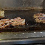 パントリー コヨーテ - ハーフパウンダー（２２８ｇ）のパテとベーコン、（左奥が通常のクォーターパウンダー（１１４ｇ）のパテ）