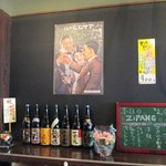 たこ焼き ジパング - 焼酎と日本酒の一升瓶が並ぶ棚、日ごとに増えてきている