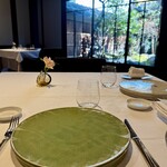 モトイ - 通されたのは、中庭を臨む窓際のテーブル。自然光がやわらかく差し込み、庭の緑がまるで絵画のように切り取られており、都会の中とは思えない穏やかさ。席の間隔もゆったり取られていて、プライベートな時間をじっくり楽しむことができます。