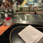 銀座うかい亭 - 半円状のグリルに沿って並ぶカウンター席。テーブルには花が。キッチン中央には地球のオブジェ