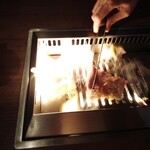 焼肉うしごろ - 大判サーロインを、網の鉄板で調理してもらっているところです。まさにファイアーダンスが凄く、キラウエア火山を彷彿とさせます。