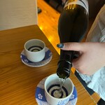 Seafood Washoku Naruki - A plastic plate is brought under the ochoko, 
                      filled to the brim with sake...!
                      Wow! What a wonderful service!