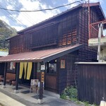 カフェ＆鉄板レストラン 藤川 - 緑色で書かれた木製の看板と黄色暖簾が印象的な旧国鉄官舎を利用した店舗
