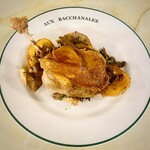 オー バカナル - 骨付き肉厚の鶏のコンフィ。下にはジャガイモとキノコのハーブグリル。ボリュームすご！