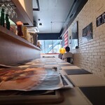 THE BURGER HOUSE 나미키점 - 매장 내부는 회색 천장과 검은색 기둥, 흰색 벽돌 벽, 검정과 흰색 체크 패턴의 타일 바닥으로 모노톤의 공간을 연출하고 있으며, BGM은 팝 음악입니다.
                      좌석은 카운터 8석, 테이블 4석 2개, 테이블 2석 1개로 총 18석입니다.