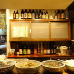 まど居 - カウンター正面にはレアな焼酎や梅酒が勢ぞろい