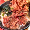 錦うどん - 店の看板が赤く、窓際でその赤が…肉うどんにごぼう天ぷら追加