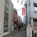 横濱飯店 - お店はラーメン横丁の入口。昼時は行列を形成。