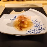 クッチーナ - ◯百合根のフリット❔
      日本で一番の百合根作りの名人から頂いております
      40分位掛けて揚げております
      上から3日間掛けて作ったコンソメの餡を掛けて
      一番上、鰹節に見えますがベーコンです　との説明