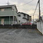 そば処 満留賀 - 駐車場　※右端の白い建物が店舗