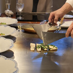 八王子うかい亭 - 鉄板で焼くのは皮の方だけ。
      熱がゆっくりと身に入ってふっくらと焼き上がるそう♪
      カチャンカチャンというリズミカルなヘラの音♩( ´ｰ`* )
      香草を乗せて焼き上げていきます。