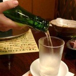 築館漁港ゑびす - 皿の上に置いた１合グラスにおねえさんがお酒を注ぎます