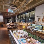 フレスタベーカリー - 店内は木板張り天井、ガラス張り壁&木板張り壁、木板張り床、ガラス張り壁の向こう側に清潔感のあるパン工房も見え、スタイリッシュ&木の癒しの感じに加え、安心感もあり寛げる空間、BGMは演奏音楽