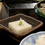 よしじ - 小鉢の蕎麦豆腐。
      蕎麦の香りがしつつも、胡麻豆腐みたいなモチプル食感♪  おいしい〜(*´༥`*)ｳﾏ~