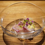 日本料理FUJI - ●ヒラアジと新玉ねぎの黄身酢和え
      漁港まで活かし、港で神経〆されたヒラアジ。 花穂紫蘇と発酵させた菜の花パウダーもふりかけてあります。