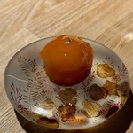 レスピラシオン - ◆甘海老 まるで大きなおはじきのような平たい球体の器に盛りつけられたこの一品は、まさにアートピースのような佇まいです。中央には卵の黄身のように美しく丸いフォルムを描いたオレンジ色のドーム。その表面には金箔がひらりと一枚添えられ、まるで高貴な宝石のように静かに輝きを放っています。