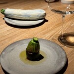 レスピラシオン - じっくりと粕漬けされたズッキーニは旨みが凝縮され、輪切りにされてお皿の上に並びます。その上には、万願寺唐辛子を焼いて作られたペーストが重なり、さらに阿岸で育った七面鳥のもも肉と砂肝をミンチにして詰めた花ズッキーニが堂々と鎮座。