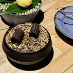 レスピラシオン - 最後に登場するのは、加賀棒茶と黒糖を混ぜて薄く焼き上げた、空洞の円筒状のお菓子。中には黒胡麻とチョコレートのコク深いクリームが忍ばせてあり、口に含めば香ばしさとまろやかな甘さが広がります。ひとつひとつに物語を感じるような、余韻豊かなデセールでした。